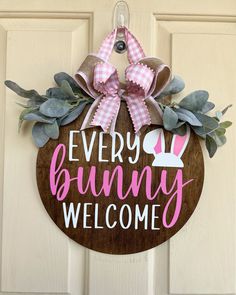 a wooden sign that says, every bunny welcomes with pink and white bows on it