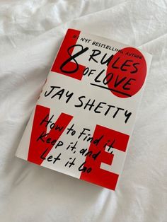 the book rules of love by jay shetty is laying on a white bed sheet