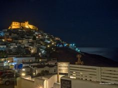a night time view of a town on top of a hill