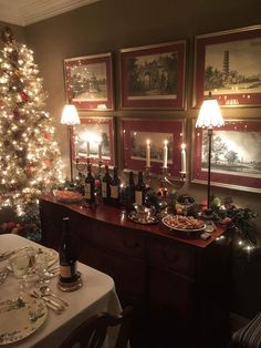 a dining room table is set for christmas dinner with wine bottles and plates on it