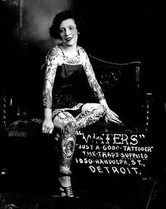 a woman sitting on top of a bench with tattoos on her arm and leggings