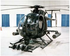 a black helicopter sitting in a hanger with wheels on it's rims