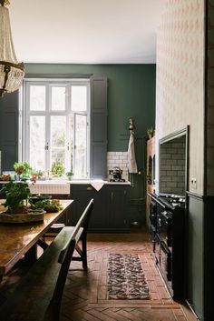 a kitchen with green walls and wooden table