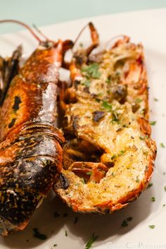 two cooked lobsters on a plate with parsley