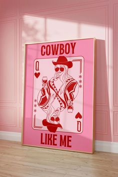 a pink poster with the words cowboy like me on it in front of a pink wall