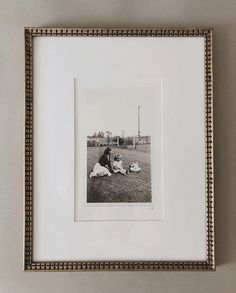 a black and white photo of two dogs laying in the grass