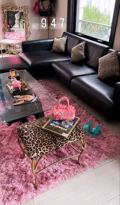 a living room with black leather couches and leopard print rugs on the floor