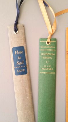two bookmarks with the words how to sail and mountain climbing on them, hanging from a string