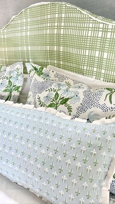 a green and white bed with pillows on it