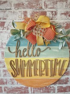 a wooden sign that says hello summertime on the side of a brick wall with leaves