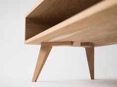 a close up of a wooden shelf on a white surface with no one around it