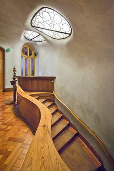 a curved wooden staircase leading up to a round window
