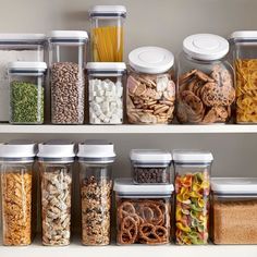 the shelves are filled with different types of food and cereal in glass containers on top of each other