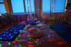 a room filled with lots of different colored lights and decorations on the floor next to windows
