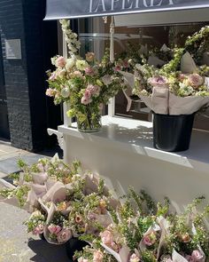 flowers are on display in front of a flower shop