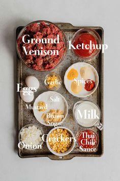 an overhead view of the ingredients for ground ketchup on a baking tray, including eggs, meats, milk, and other condiments