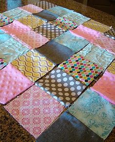 a patchwork table runner made out of different colored fabrics on a granite countertop