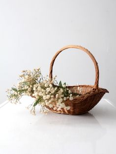 a wicker basket with white flowers in it