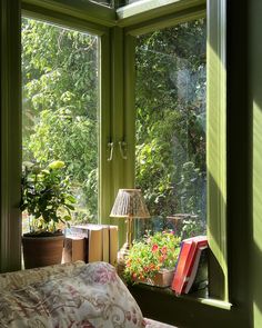 a bedroom with green walls and plants in the window sill