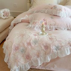 a bed with pink comforters and pillows on it