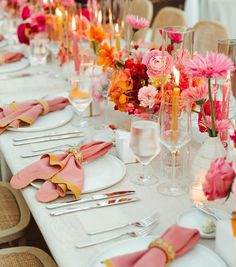 the table is set with pink and orange flowers