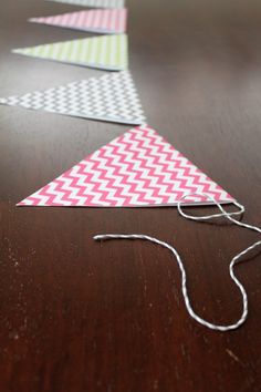 some paper triangles are sitting on a table with string in the middle and one is red, white and green