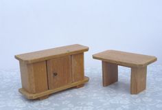two small wooden furniture pieces sitting on top of a table
