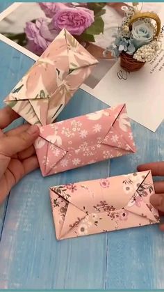 someone is making an origami triangle out of paper and some other things on the table
