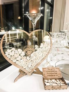 a heart shaped display on top of a table with wine glasses and other items in front of it