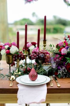 the table is set with candles, plates and napkins for an elegant wedding reception