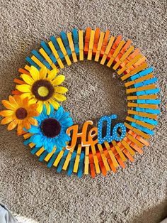 a wreath made out of popsicle sticks with sunflowers and the word hello painted on it