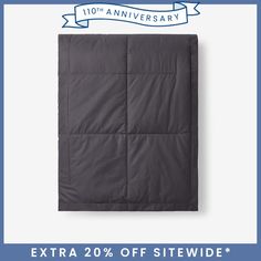 the dark grey quilted blanket is folded up