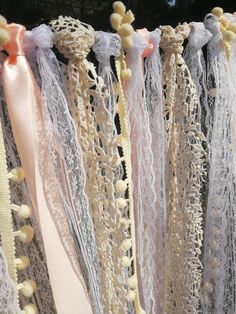 there are many different types of laces hanging on the clothes line with ribbons attached to them