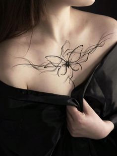a woman wearing a black dress with a flower tattoo on her chest