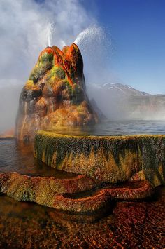 the water spewing out from the rocks is colored orange, yellow and green