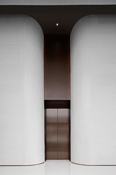 an open door in the middle of two tall white pillars