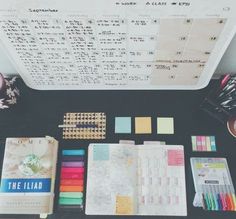 the contents of a planner laid out on a table with pens, markers and pencils
