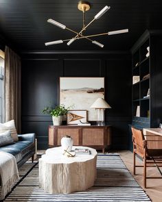 a living room with black walls and furniture