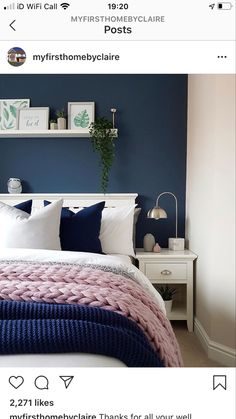 a bedroom with blue walls, white bedding and pink blanket on the headboard