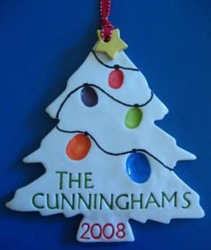 a ceramic christmas tree ornament with lights on it's top and the words, the cunningams