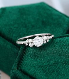a diamond ring sitting on top of a green cloth