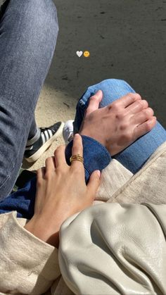 two people are sitting on the ground and one is touching another person's hand