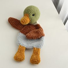 a crocheted stuffed duck sitting on top of a table