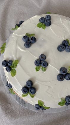 a cake with white frosting and blueberries on it
