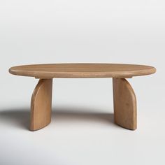 an oval wooden table with curved legs on a white background in front of the camera