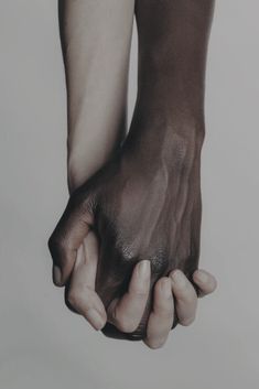 two hands holding each other in front of a white background