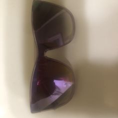 a pair of sunglasses sitting on top of a white table next to a wall and window