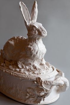 a sculpture of a rabbit sitting in a bowl
