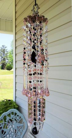 a chandelier hanging from the side of a house in front of a porch