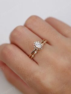a woman's hand with a ring on it and a diamond in the middle
